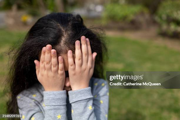 portrait of young multiracial girl with hands covering eyes during 2024 total solar eclipse - annular solar eclipse stock pictures, royalty-free photos & images