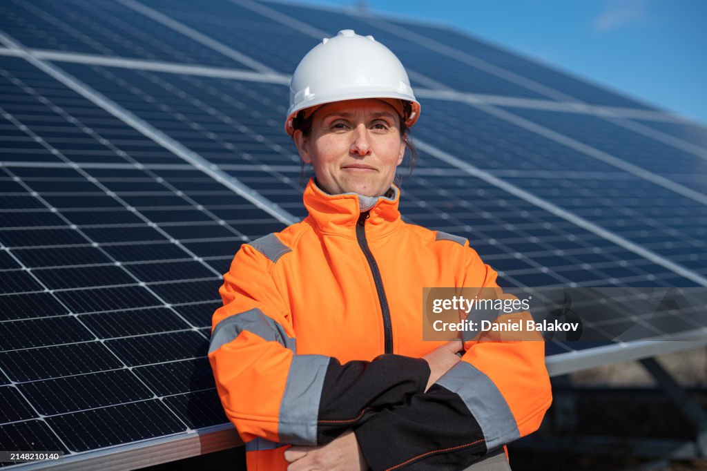 Female Engineer Portrait on Solar Panels Background. Solar City.