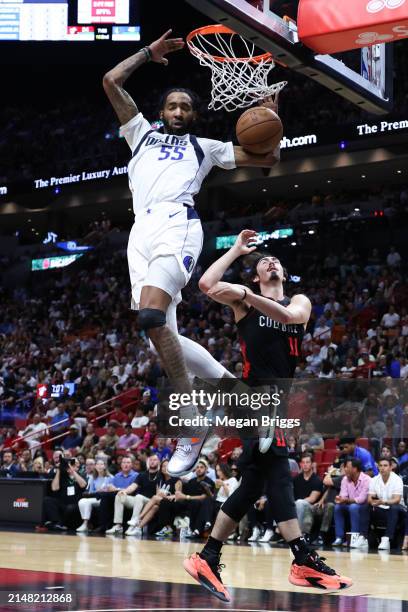 Derrick Jones Jr. #55 of the Dallas Mavericks dunks the over over Jaime Jaquez Jr. #11 of the Miami Heat during the second quarter at Kaseya Center...