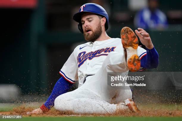 Jared Walsh of the Texas Rangers scores a run in the fourth inning against the Oakland Athletics at Globe Life Field on April 10, 2024 in Arlington,...