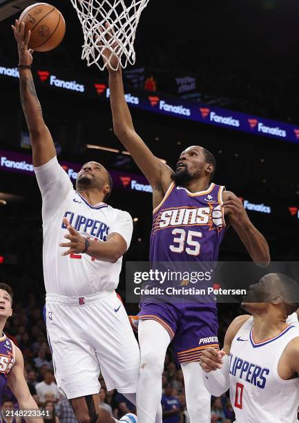 Norman Powell of the LA Clippers lays up a shot past Kevin Durant of the Phoenix Suns during the second half of the NBA game at Footprint Center on...