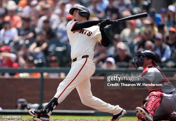 Wilmer Flores of the San Francisco Giants hits a sacrifice fly scoring Nick Ahmed against the Washington Nationals in the bottom of the fifth inning...