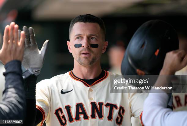 Nick Ahmed of the San Francisco Giants is congratulated by teammates after he scored against the Washington Nationals in the bottom of the fifth...