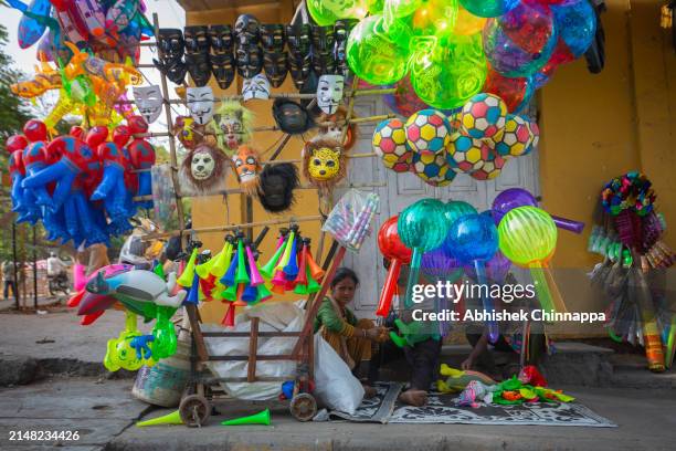 Family sells masks and balloons on a pedestrian pavement before Eid Al-Fitr prayers on April 11, 2024 in Bengaluru, India. Muslims worldwide observe...