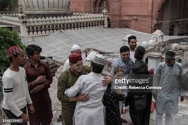 Muslims offer greetings following Eid Al-Fitr prayers at the Hazrat Nizamuddin Dargah on April 11, 2024 in Delhi, India. Muslims worldwide observe...