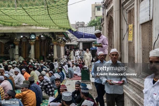 Muslims leave offerings during celebrations to mark Eid Al-Fitr at the Hazrat Nizamuddin Dargah on April 11, 2024 in Delhi, India. Muslims worldwide...