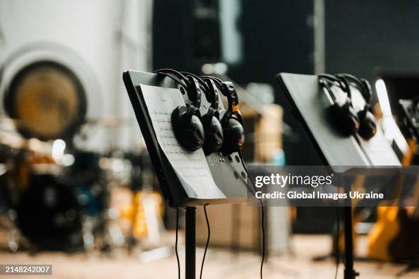 Headphones hang on a music stand, on which lies a letter with musical notation, on the scene of Recording House of Ukrainian Radio during the filming...