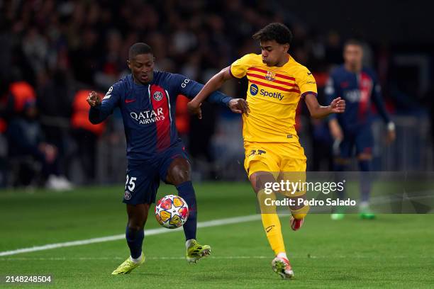 Nuno Mendes of Paris Saint-Germain competes for the ball with Lamine Yamal of FC Barcelona during the UEFA Champions League quarter-final first leg...