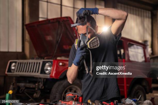 repairman puts on protective air mask - respirator mask stock pictures, royalty-free photos & images
