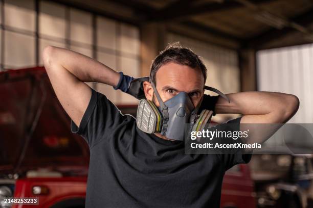 repairman puts on protective air mask - respirator mask stock pictures, royalty-free photos & images