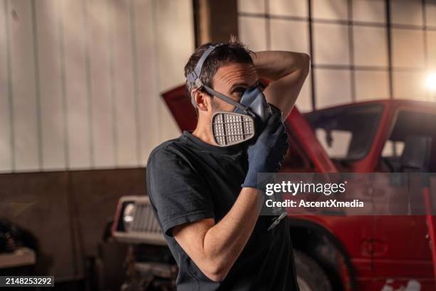 repairman puts on protective air mask - respirator mask stock pictures, royalty-free photos & images