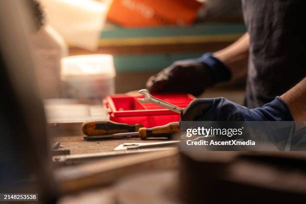 repair shop owner chooses tool in workshop - screwdriver stock pictures, royalty-free photos & images