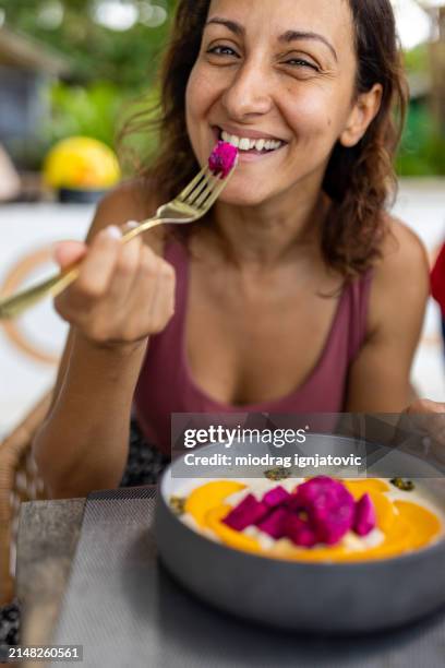 woman enjoying a smoothie bowl - pitaya stock pictures, royalty-free photos & images
