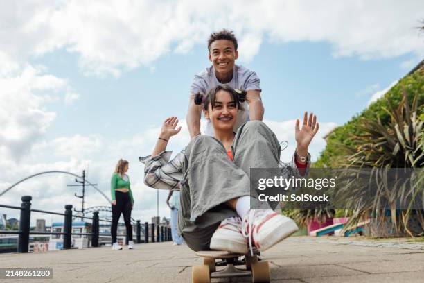 pushing friends on skateboard - skater boy stockfoto's en -beelden
