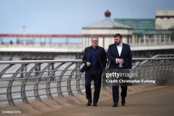 Labour Party leader Sir Keir Starmer and the party's candidate for Blackpool South Chris Webb talk as they walk on the promenade on April 11, 2024 in...