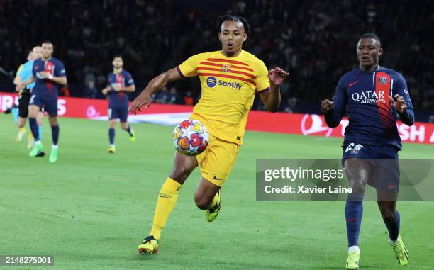 Jules Kounde of FC Barcelona in action with Nuno Mendes of Paris Saint-Germain during the UEFA Champions League quarter-final first leg match between...