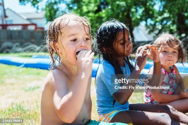 young boy eats ice cream with friends outside - chinese eating backyard stock pictures, royalty-free photos & images