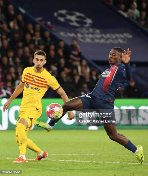 Nuno Mendes of Paris Saint-Germain play the ball with Lamine Yamal of FC Barcelona during the UEFA Champions League quarter-final first leg match...