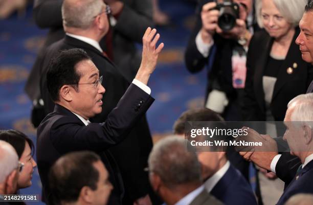 Japanese Prime Minister Fumio Kishida greets lawmakers as he departs after addressing a joint meeting of Congress in the House of Representatives at...