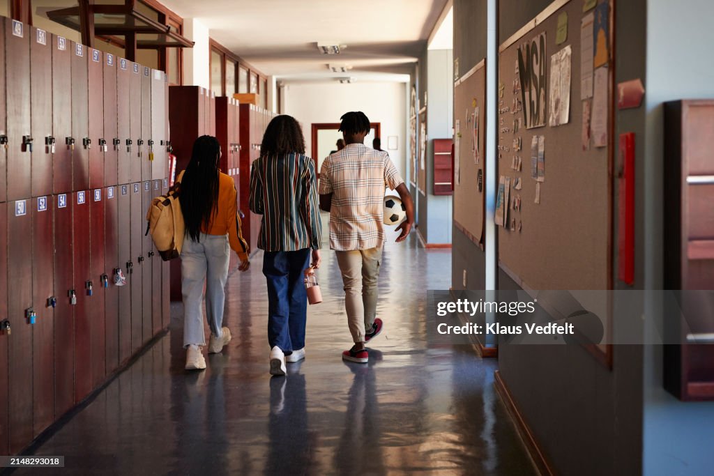 Male and female students walking in corridor