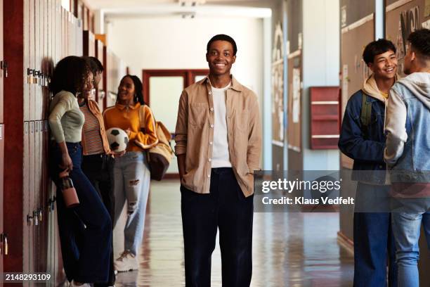 smiling teenage boy with hands in pockets amidst friends - open day 13 stock pictures, royalty-free photos & images