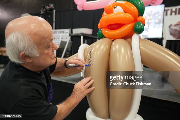 English actor Rusty Goffe autographs a balloon figure during an event related to the film 'Willie Wonka and the Chocolate Factory' at the Chocolate...