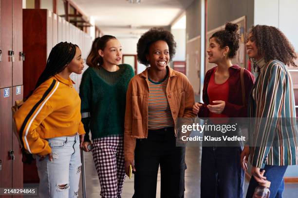 happy girls discussing in corridor - only teenage girls stock pictures, royalty-free photos & images