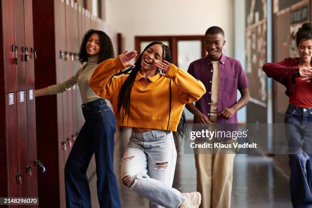 happy students enjoying dance together by lockers - open day 13 stock pictures, royalty-free photos & images