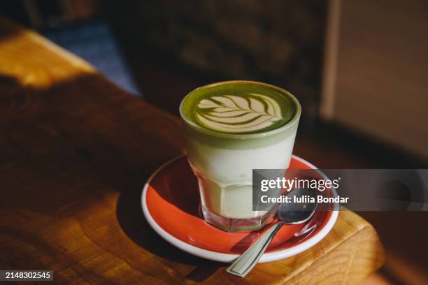 matcha latte in a glass - grüner tee stock-fotos und bilder