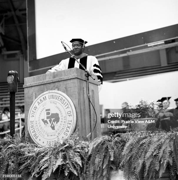 The 4th President of President of Prairie View A&M University at podium addressing the graduating class during a commencement ceremony.