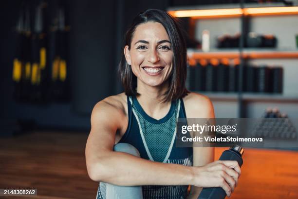 mujer joven segura de sí misma que hace ejercicio en un gimnasio. - entrenamiento deportivo fotografías e imágenes de stock