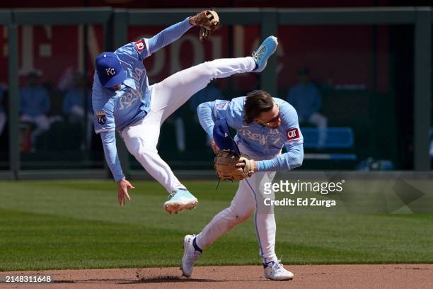 Nick Loftin of the Kansas City Royals leaps over Bobby Witt Jr. #7 as Witt Jr. Fields a ball hit by Victor Caratini of the Houston Astros in the...