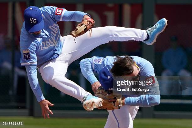 Nick Loftin of the Kansas City Royals leaps over Bobby Witt Jr. #7 as Witt Jr. Fields a ball hit by Victor Caratini of the Houston Astros in the...