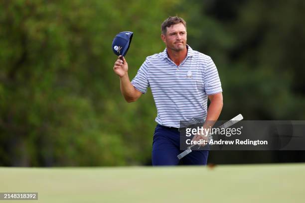 Bryson DeChambeau of the United States acknowledges the crowd as he walks to the 18th green during the first round of the 2024 Masters Tournament at...