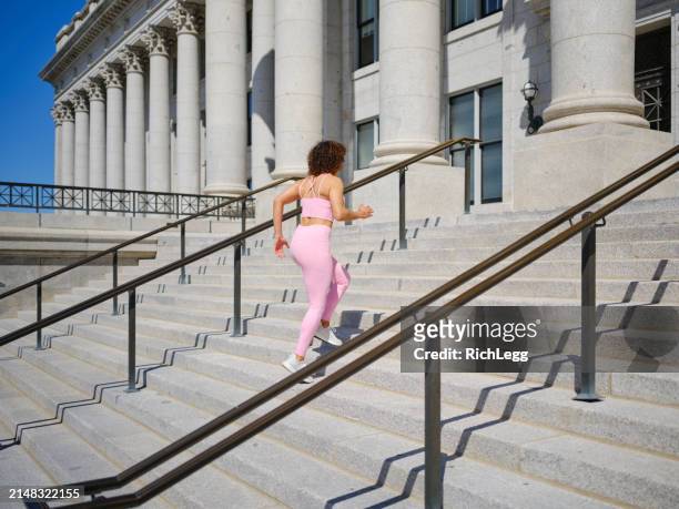 woman running up steps - government building steps stock pictures, royalty-free photos & images