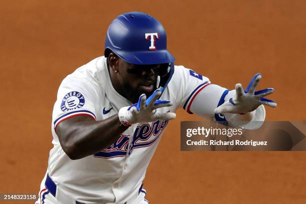 Adolis García of the Texas Rangers gestures toward the dugout after getting a hit against the Oakland Athletics in the seventh inning at Globe Life...