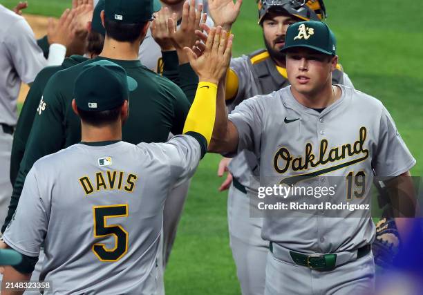 Davis high fives Mason Miller of the Oakland Athletics after the win over the Texas Rangers at Globe Life Field on April 11, 2024 in Arlington, Texas.