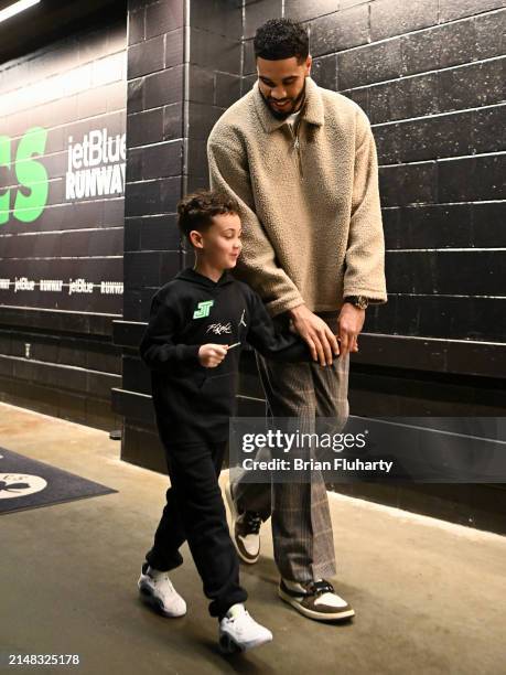 Jayson Tatum of the Boston Celtics and his son Deuce walk into the arena before a game against the New York Knicks at the TD Garden on April 11, 2024...