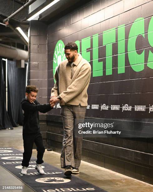 Jayson Tatum of the Boston Celtics and his son Deuce walk into the arena before a game against the New York Knicks at the TD Garden on April 11, 2024...