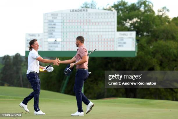 Cameron Smith of Australia and Wyndham Clark of the United States shake hands on the 18th green during the first round of the 2024 Masters Tournament...