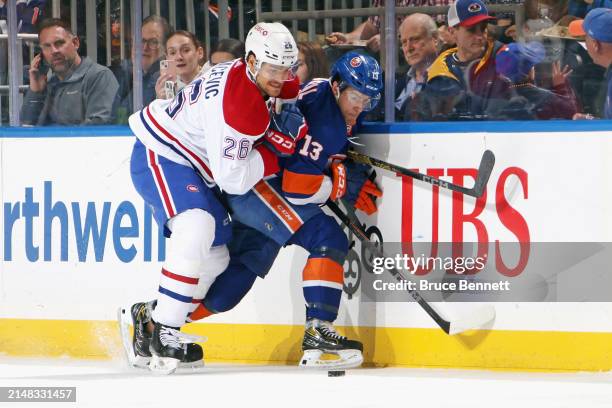 Johnathan Kovacevic of the Montreal Canadiens checks Mathew Barzal of the New York Islanders during the first period at UBS Arena on April 11, 2024...