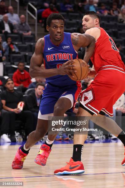 Jalen Duren of the Detroit Pistons tries to drive around Nikola Vucevic of the Chicago Bulls during the first half at Little Caesars Arena on April...