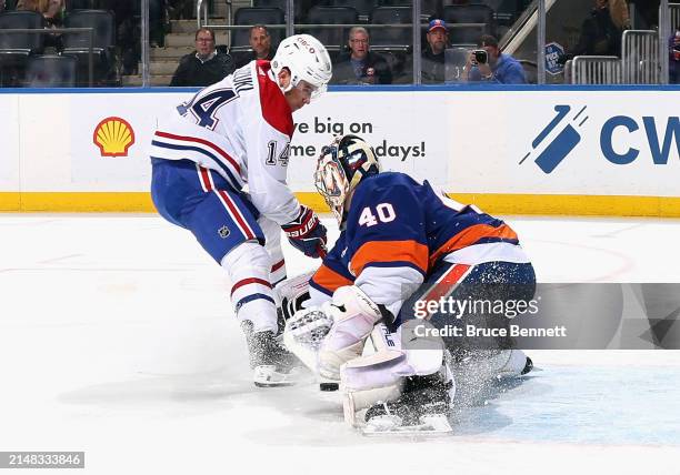 Nick Suzuki of the Montreal Canadiens is stopped by Semyon Varlamov of the New York Islanders during the first period at UBS Arena on April 11, 2024...