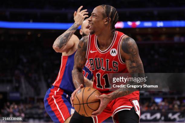 DeMar DeRozan of the Chicago Bulls tries to get a shot off around Evan Fournier of the Detroit Pistons during the second half at Little Caesars Arena...