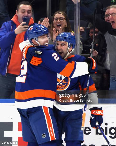 Kyle Palmieri of the New York Islanders celebrates his game-winning overtime goal against the Montreal Canadiens and is joined by Mike Reilly at UBS...