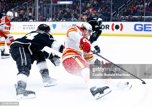 Martin Pospisil of the Calgary Flames skates the puck against Vladislav Gavrikov of the Los Angeles Kings in the first period at Crypto.com Arena on...