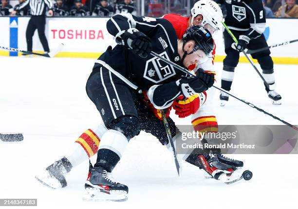 Mikey Anderson of the Los Angeles Kings skates the puck against Ilya Solovyov of the Calgary Flames in the second period at Crypto.com Arena on April...
