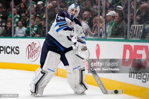 Laurent Brossoit of the Winnipeg Jets plays the puck behind his net during the first period against the Dallas Stars at American Airlines Center on...