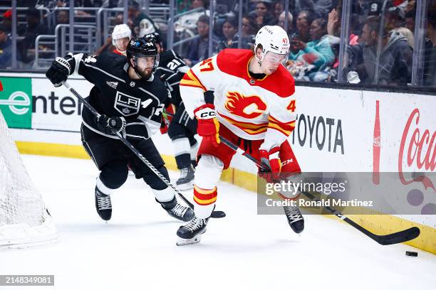 Connor Zary of the Calgary Flames skates the puck against Phillip Danault of the Los Angeles Kings in the third period at Crypto.com Arena on April...