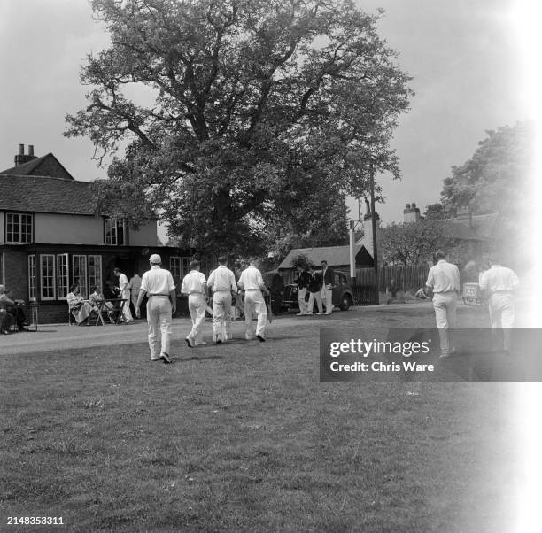 The teams adjourn to 'The Cricketers' public house as their match breaks for lunch in the village of Littlewick Green, Berkshire, England, 1949.